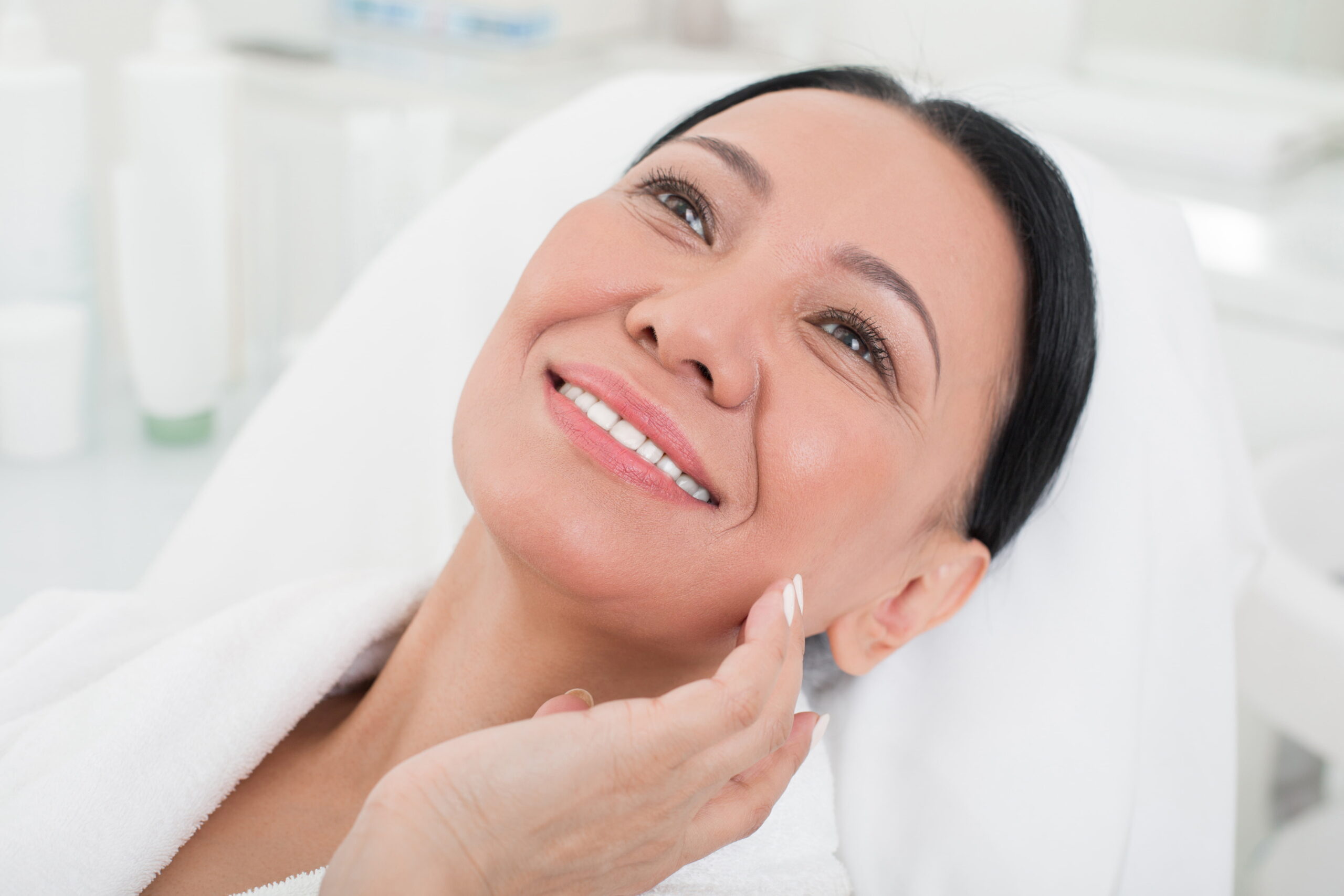 A smiling woman with smooth, radiant skin enjoys a relaxing treatment at Serenity MedSpa, highlighting the rejuvenating effects of Botox.