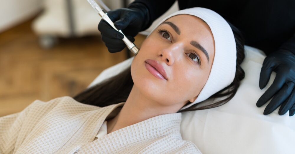 Woman receiving a HydraFacial treatment with a handheld device