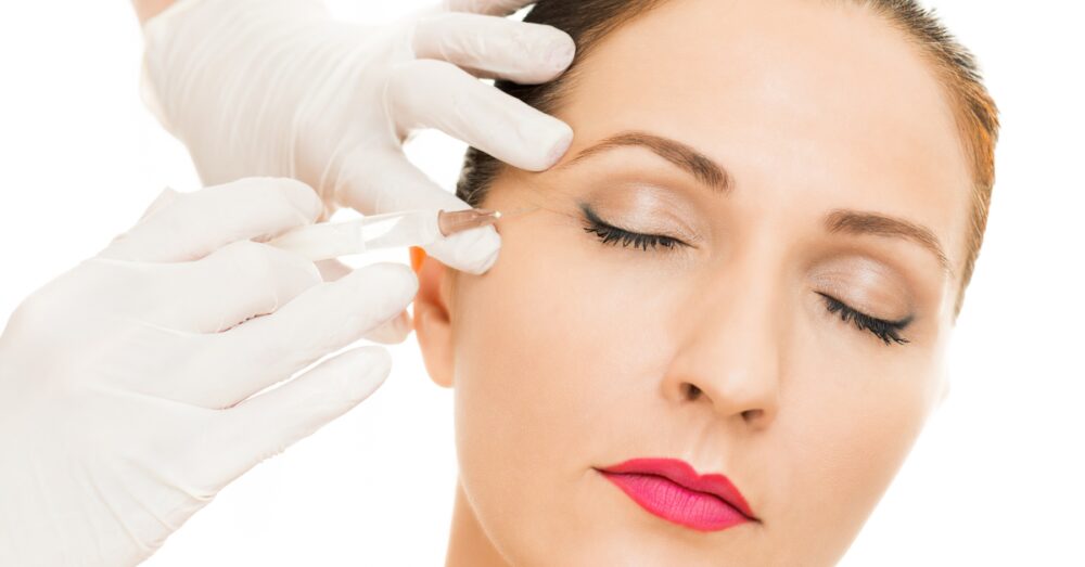 A provider performing a facial injection treatment on a female