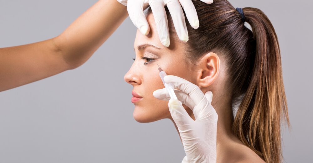 A woman receiving a cosmetic injection near her eye