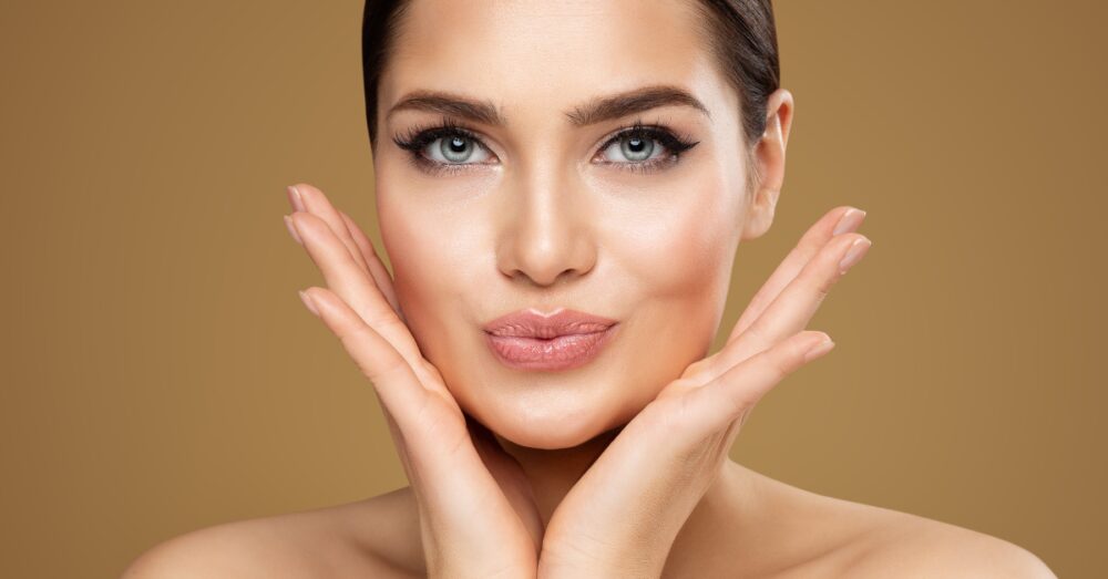 Woman with full lips cradling her face with her hands